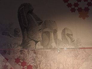 Buste de Pierre Loti en uniforme de marin, arborant la Légion d'honneur, sculpté par Raymond Sudre en 1935, exposé au musée national de la Marine à Rochefort, devant une fresque évoquant les Moaïs de l’île de Pâques.