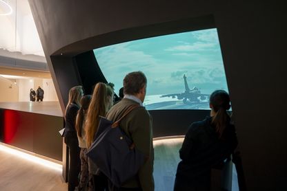 Public devant le film immersif d'accueil du musée 