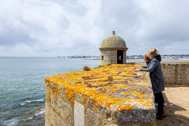 Deux personnes regardent la mer depuis les remparts 