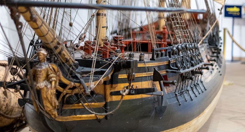 Large-scale wooden sailing ship model The ship has three masts and multiple sails made of beige fabric