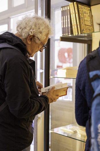 Gros plan sur un visiteur feuilletant un ouvrage en boutique