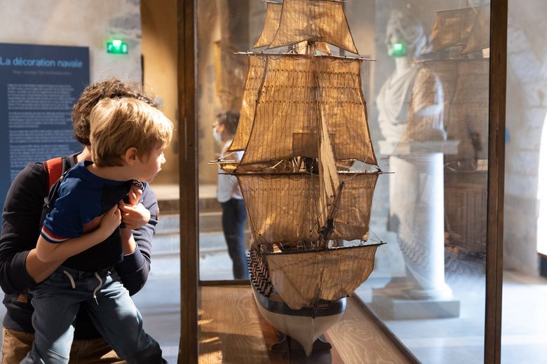 Enfant portée par un parent regardant une maquette 